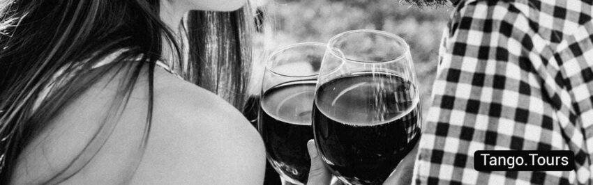 Two glasses of wine are in front of a pitcher.